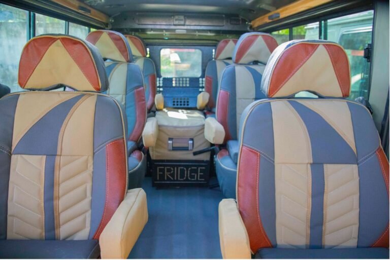 Inside an Asili Trails Land Cruiser: six window seats with armrests and a fridge at the back