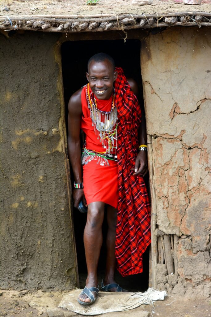 Maasai man stepping out of a traditional house