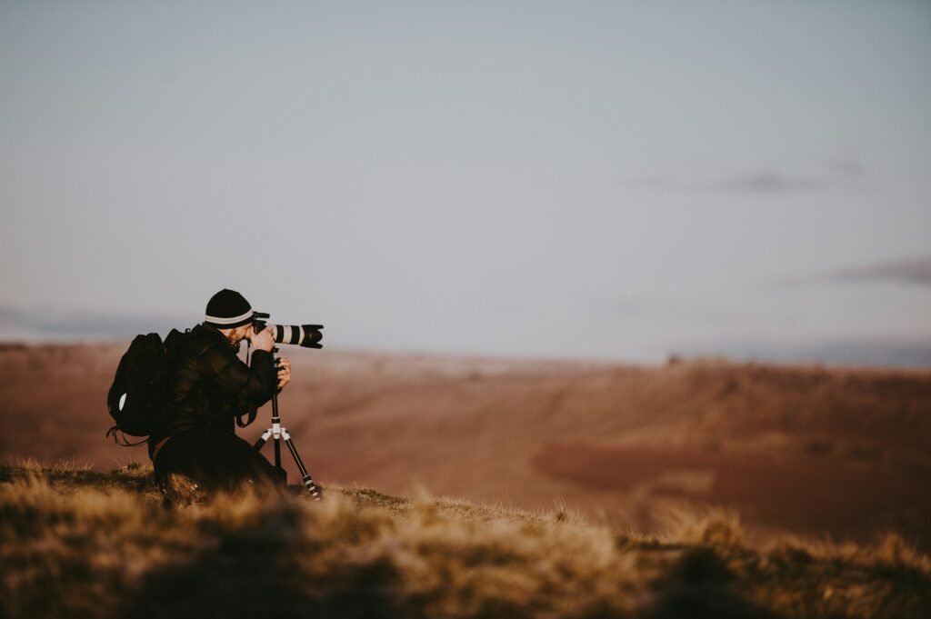Photographer with a telephoto lens on the plains at golden hour