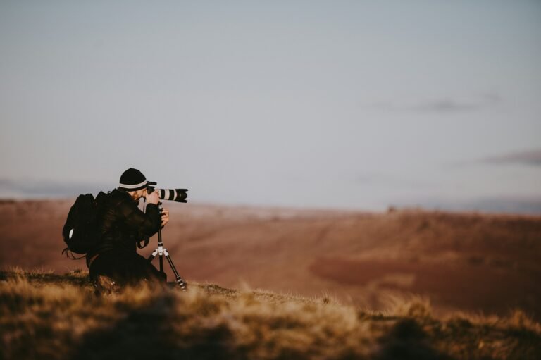 Photographer with a telephoto lens on the plains at golden hour